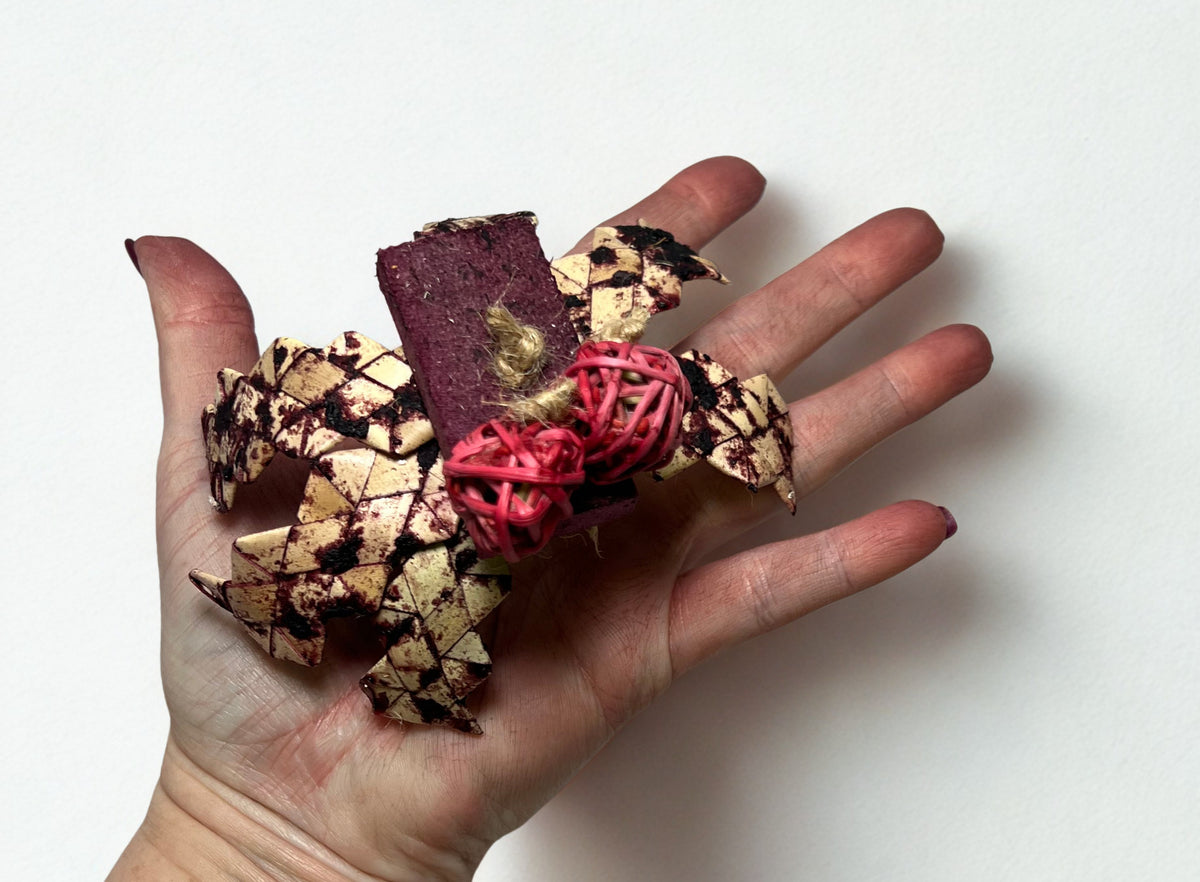 Chew Toy made from palm leaf, balsa and vine balls in hand for size